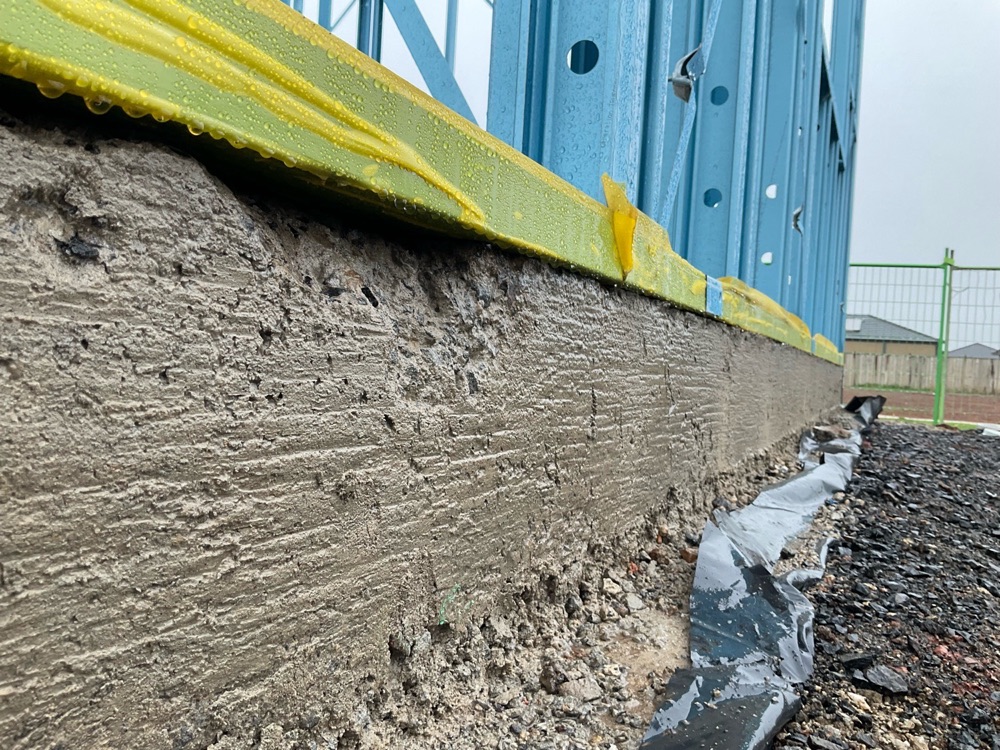Frame bottom plates overhanging the slab by more than 10mm, noted during a frame inspection in Melton South
